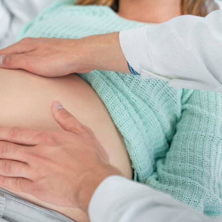 Close,Up,Shot,Of,Male,Doctor,Examining,Pregnant,Woman,Lying