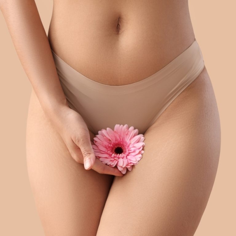 Beautiful,Young,Woman,In,Panties,With,Gerbera,Flower,On,Beige
